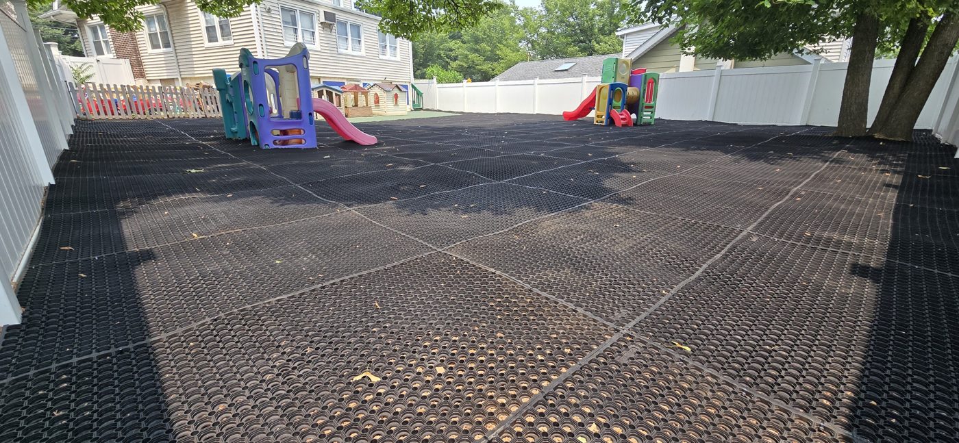 Adventureland Daycare playground in Paramus, NJ, rubber mats laid over existing mulch for a firm ADA-accessible surface
