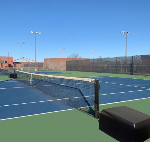 Portable net system on weighted bases set up on a school tennis court