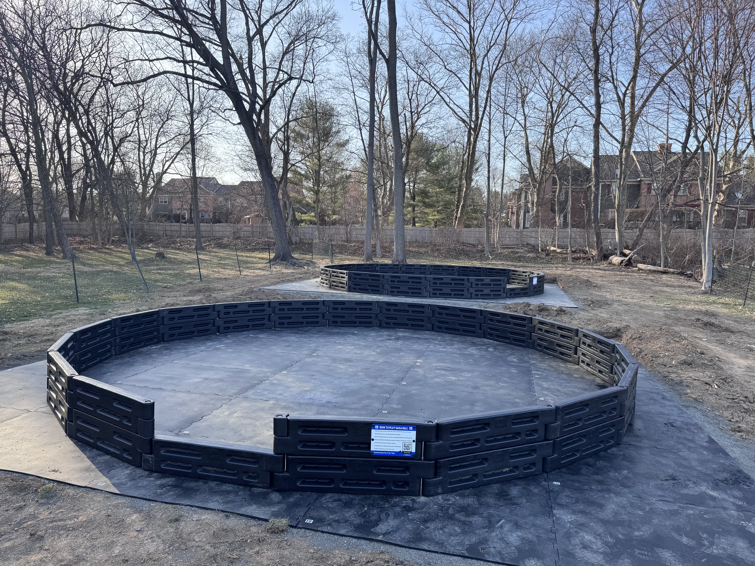Two gaga ball pits with black plastic walls and rubber floor mats at River Crossing YMCA in Doylestown, PA