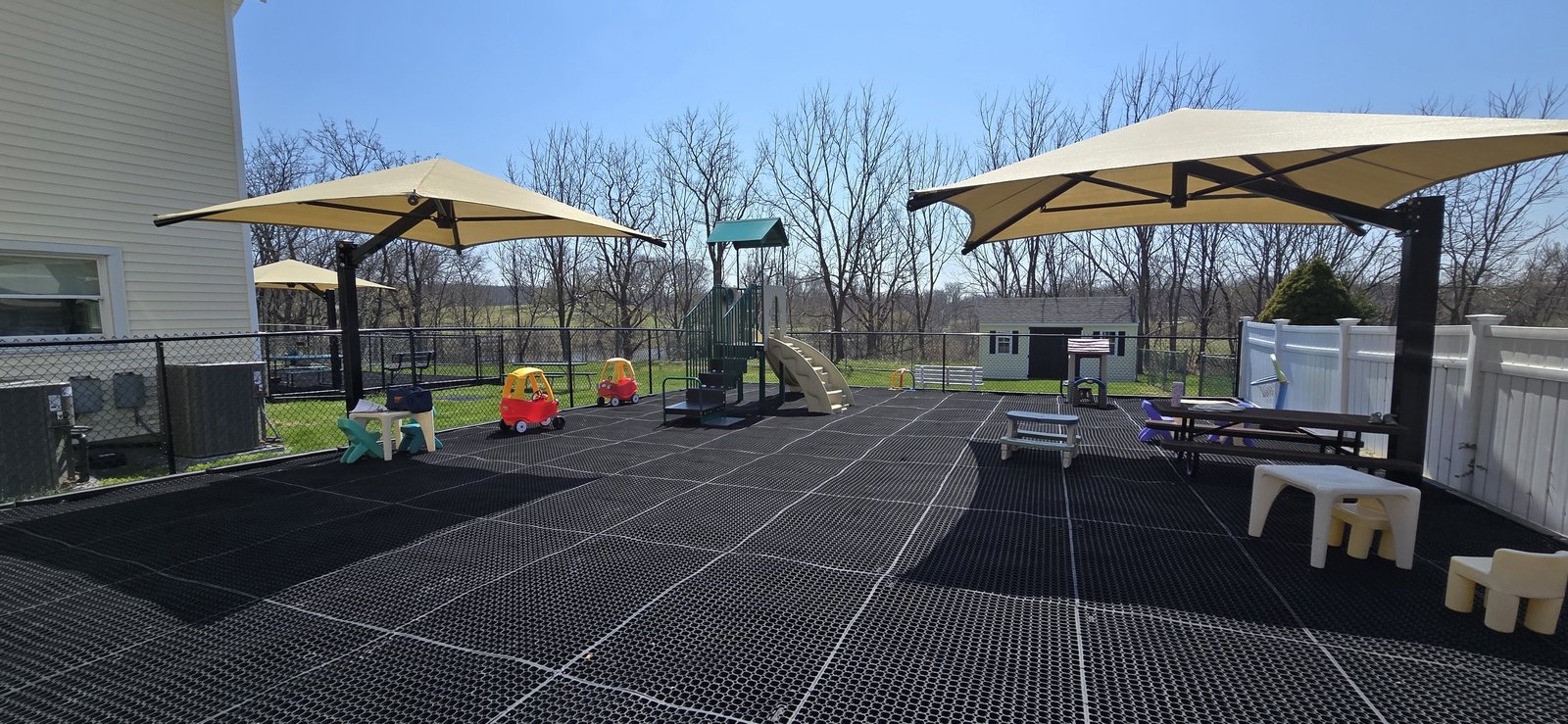 Shade structures over accessible playground matting at Second Home Childcare Center, Wantage
